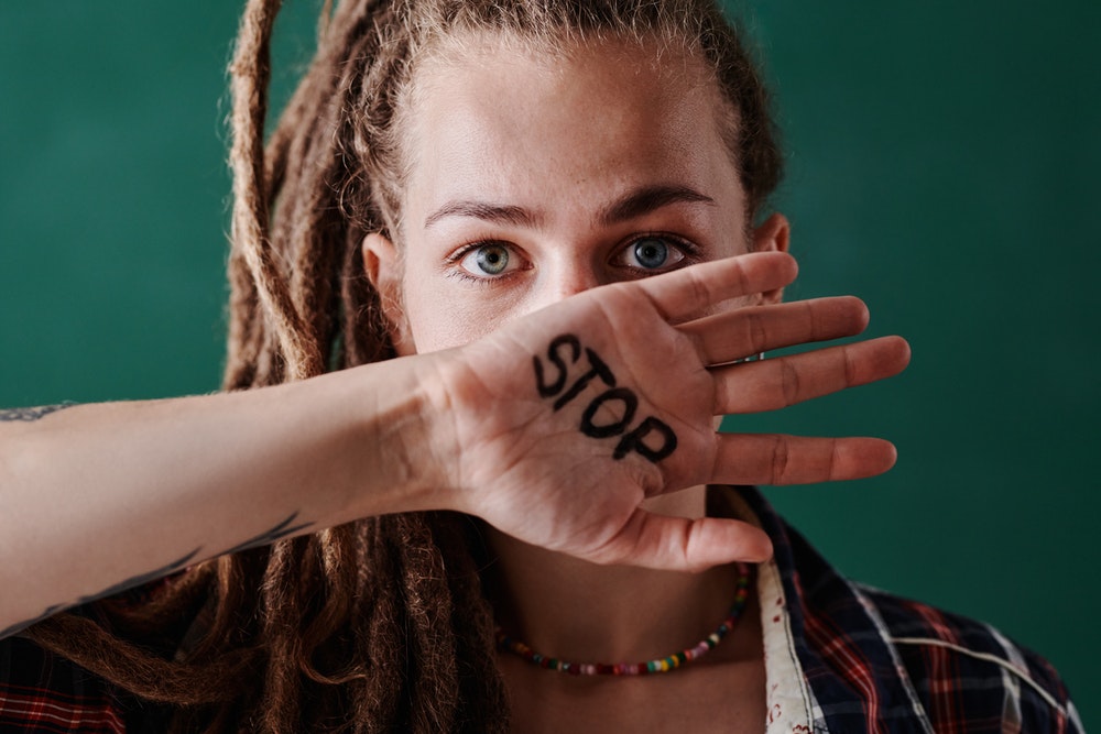 Ragazza con scritta stop sulla mano, foto Mikael Blomkvist
